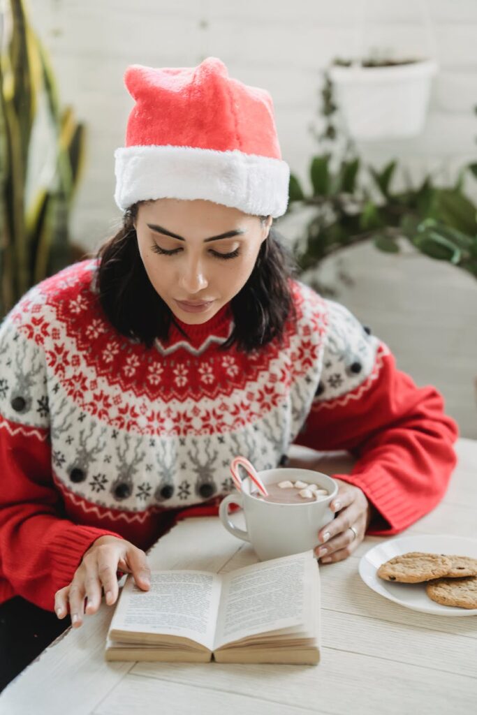 young woman with hot cocoa and book
